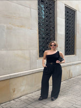 A blonde girl wears a pair of pants